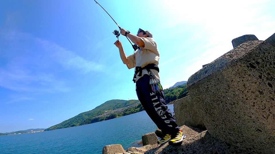 青い海に向かってエギングを楽しむアングラー